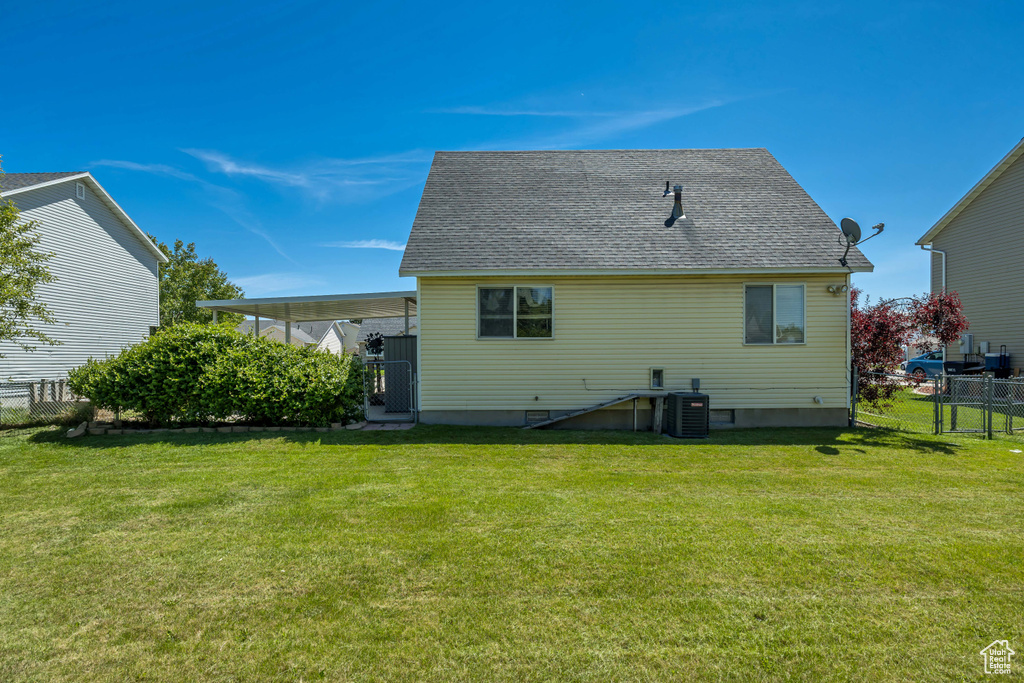 Back of house featuring central air condition unit and a shingled roof