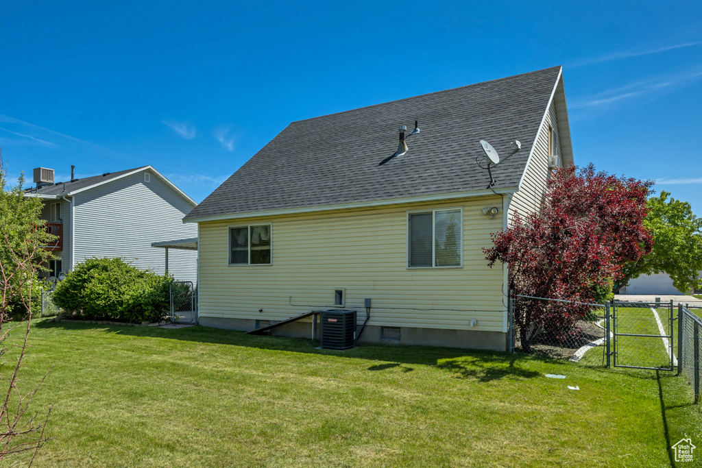 Rear view of house with a shingled roof, a gate, and central air condition unit