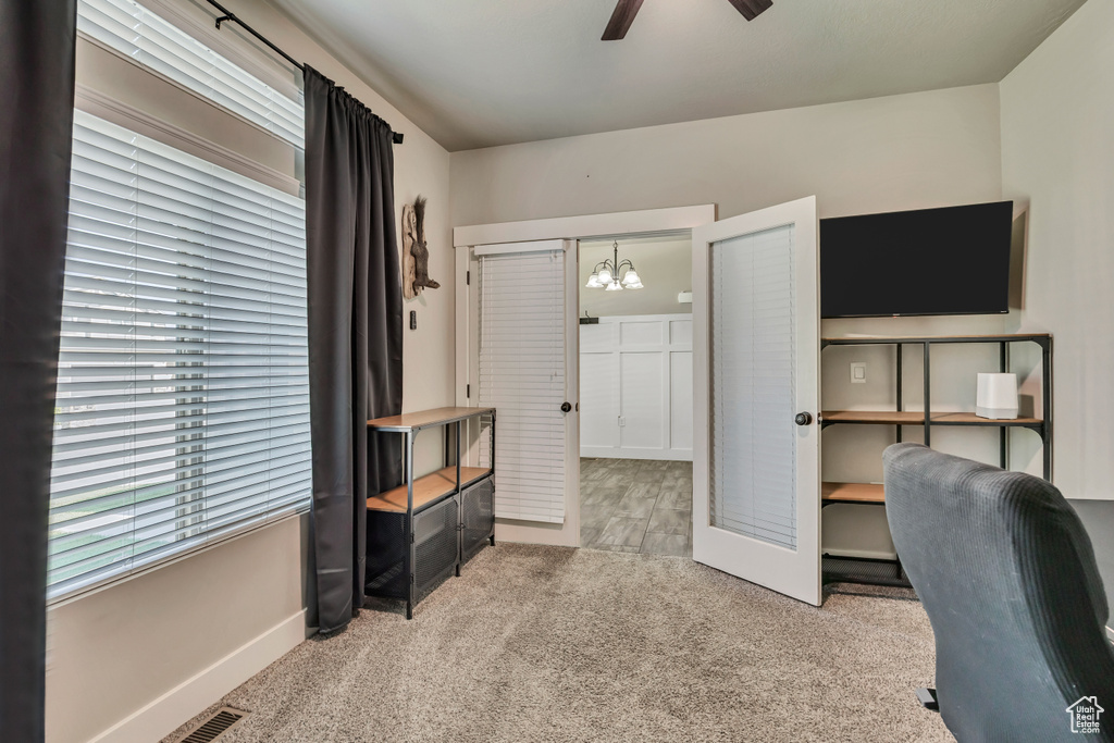 Office featuring carpet flooring, ceiling fan, baseboards, and a chandelier