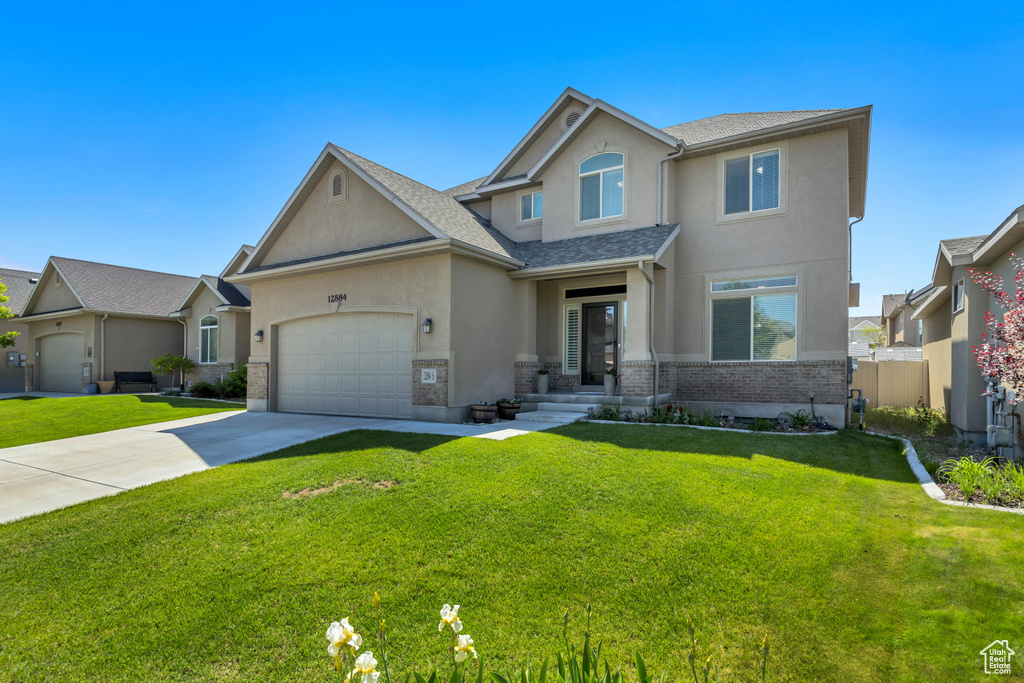 View of front facade featuring stucco siding, driveway, an attached garage, and a shingled roof