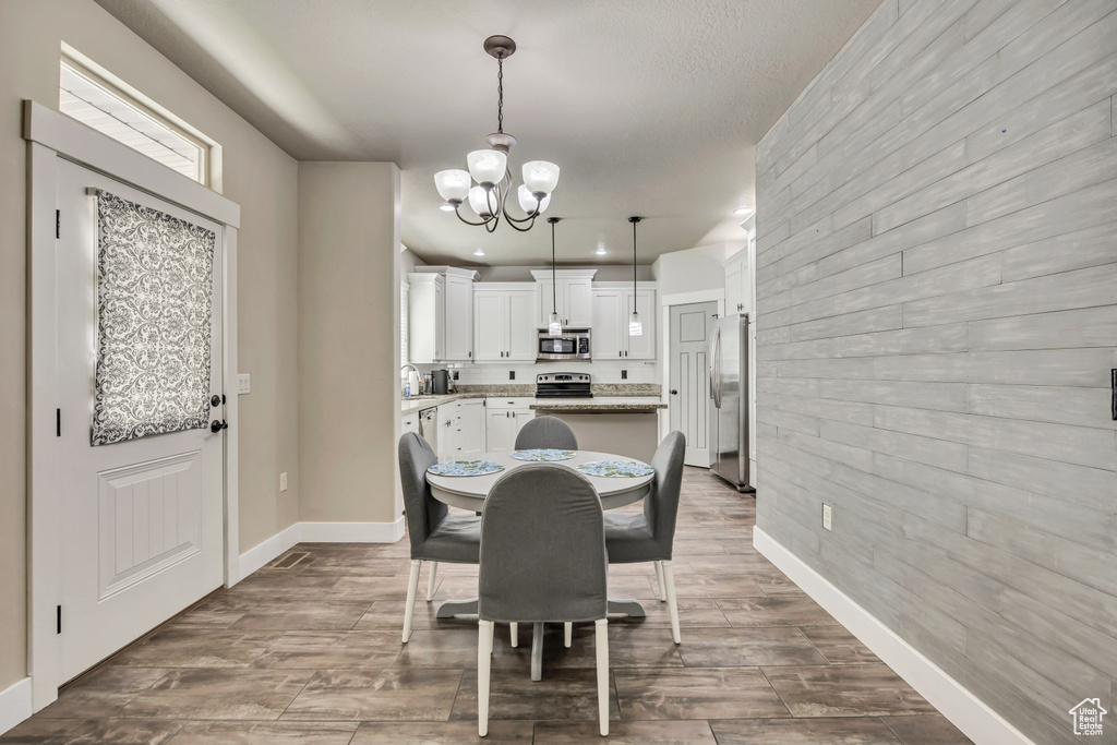 Dining space featuring a chandelier, baseboards, and wood finished floors