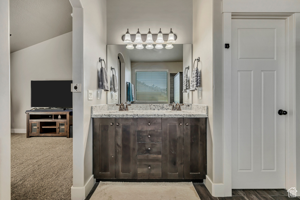 Full bath featuring double vanity and baseboards