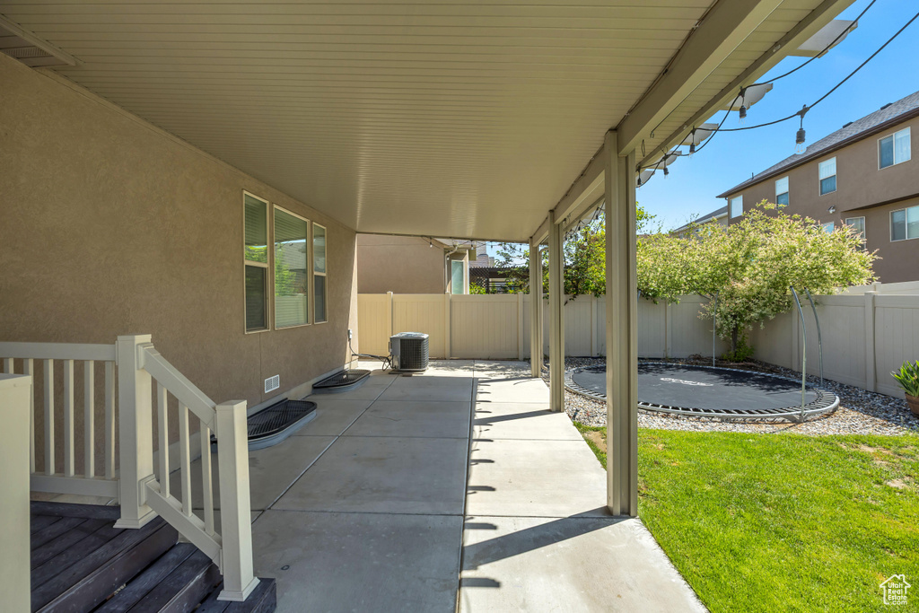 View of patio with central air condition unit and a trampoline