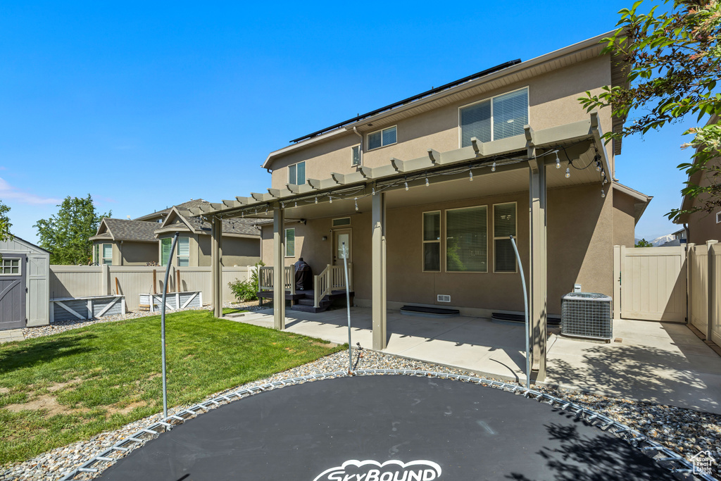Back of house featuring stucco siding, a patio, central AC, and a gate