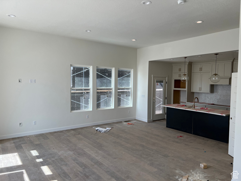 Kitchen featuring wood finished floors, backsplash, decorative light fixtures, recessed lighting, and light countertops