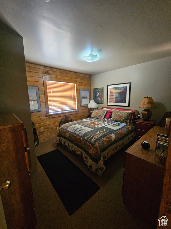 Bedroom featuring wood walls and carpet