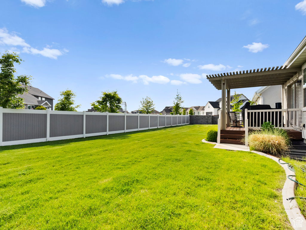 View of yard with a wooden deck, a pergola, and a residential view