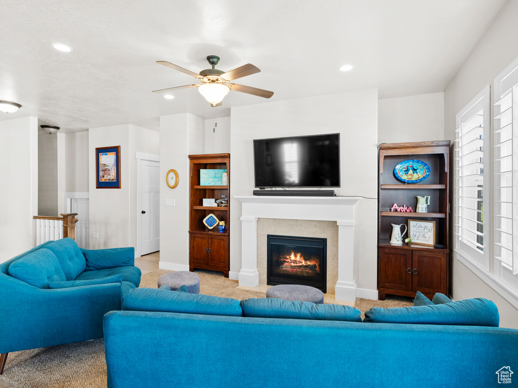 Carpeted living area with recessed lighting, ceiling fan, a tile fireplace, and baseboards