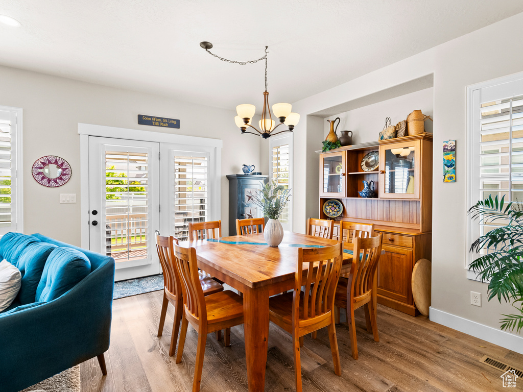 Dining area featuring plenty of natural light, a chandelier, and light wood finished floors