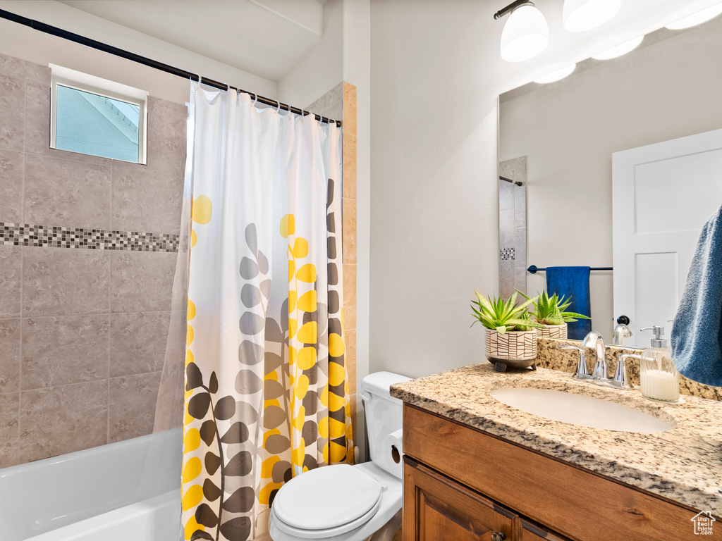 Full bathroom with toilet, vanity, and shower / bath combo
