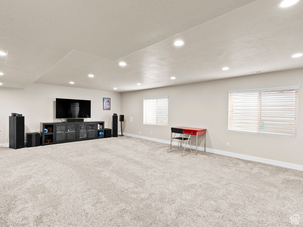 Living area with carpet flooring, baseboards, and recessed lighting