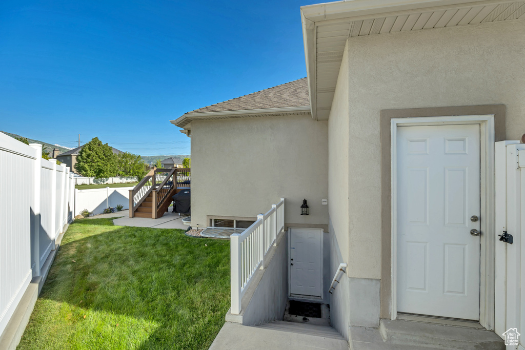 Doorway to property with stucco siding and a shingled roof