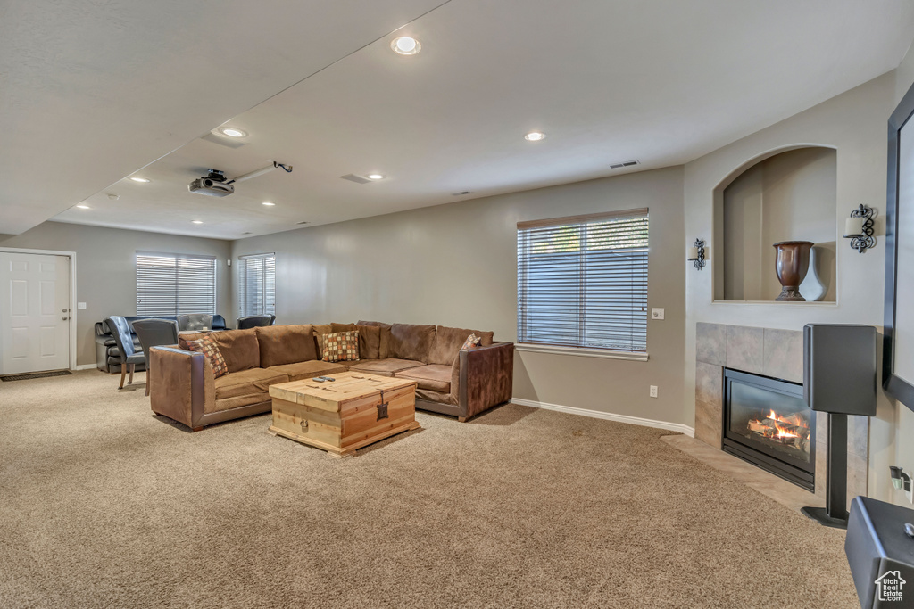 Carpeted living area with baseboards, recessed lighting, and a tile fireplace