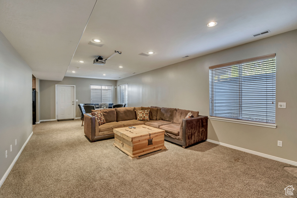 Living room with light carpet, baseboards, recessed lighting, and healthy amount of natural light