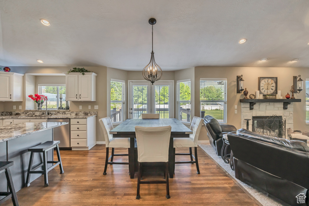 Dining space featuring plenty of natural light, a fireplace, dark wood-style floors, baseboards, and recessed lighting