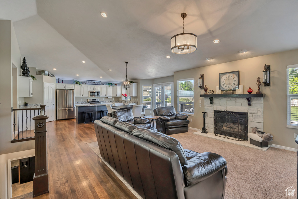Living area featuring a chandelier, a fireplace, plenty of natural light, recessed lighting, and baseboards