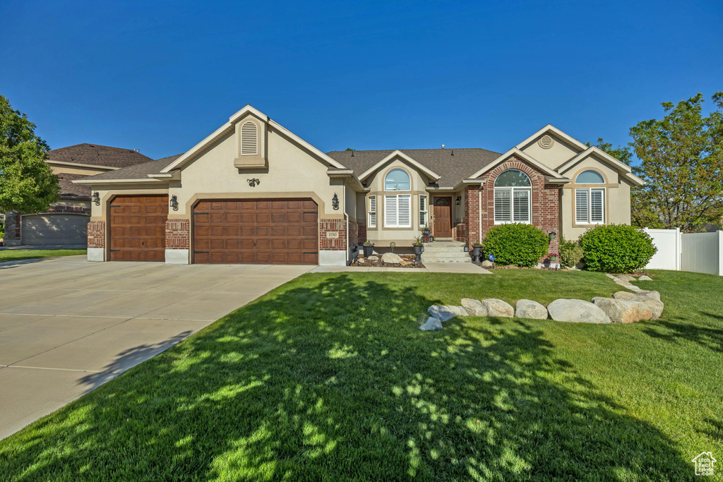 Single story home featuring an attached garage, driveway, and stucco siding