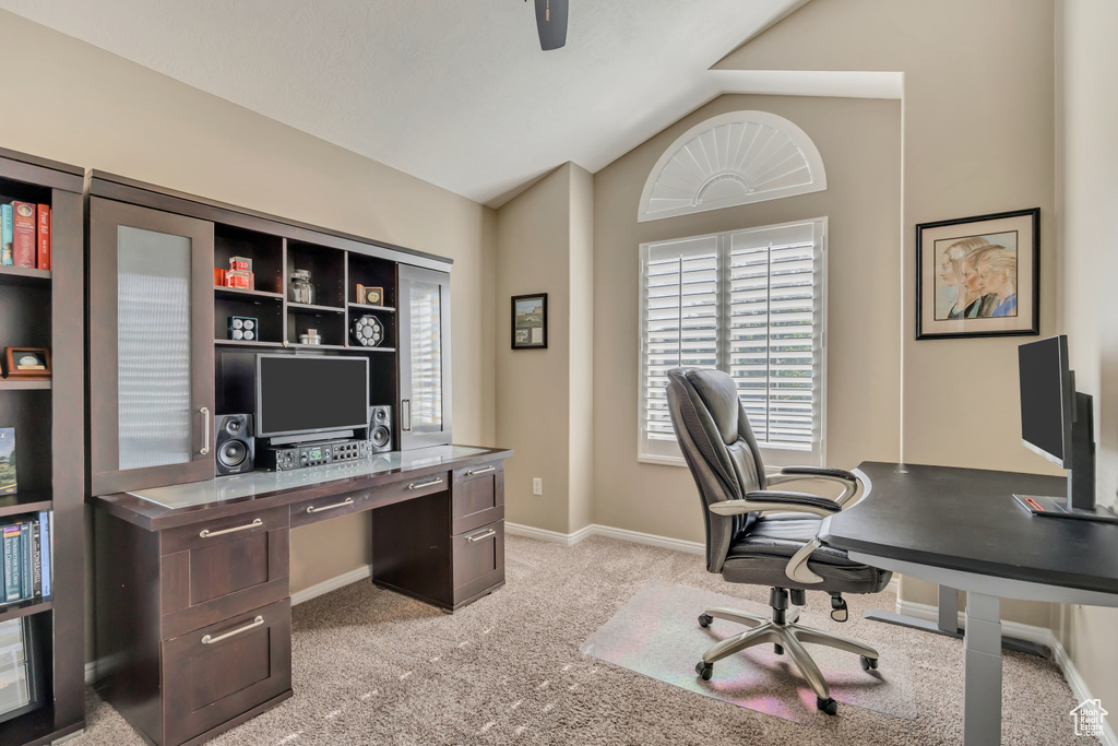 Office area featuring light carpet, vaulted ceiling, and baseboards
