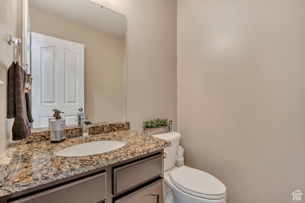 Half bath featuring vanity and toilet