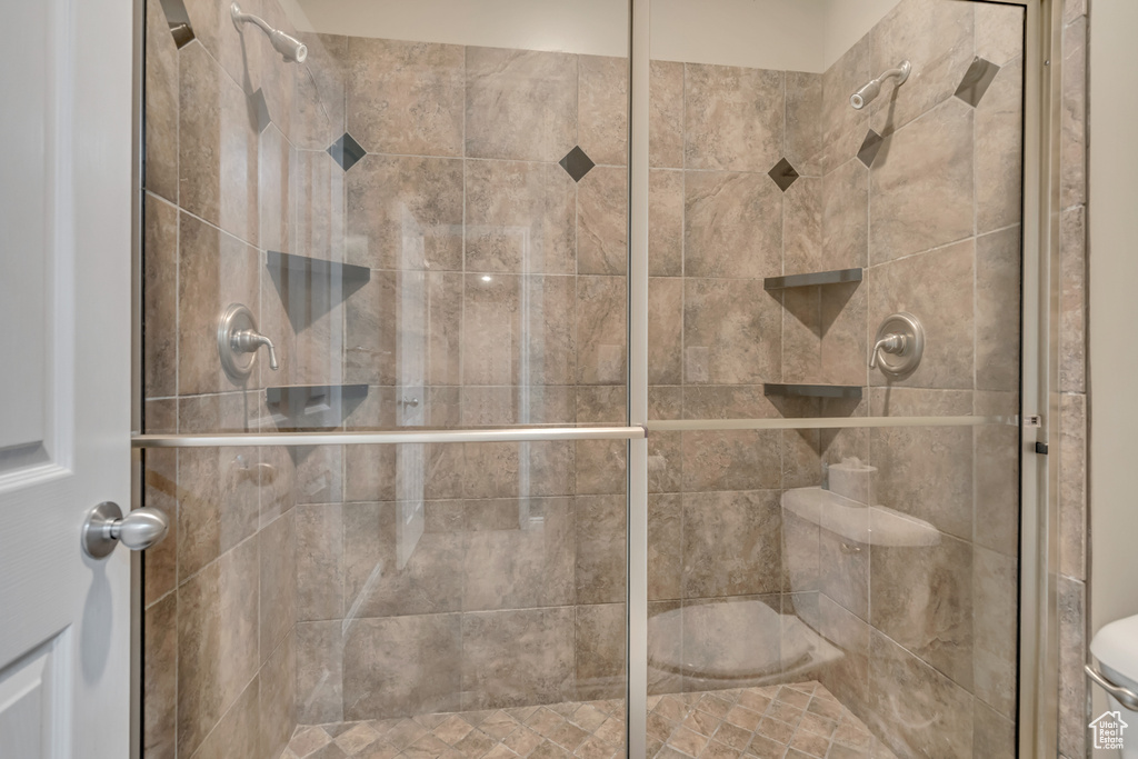 Bathroom featuring toilet and a stall shower