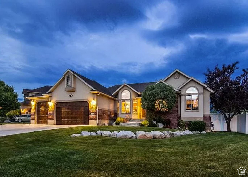 Ranch-style house with a front lawn, stucco siding, driveway, and an attached garage