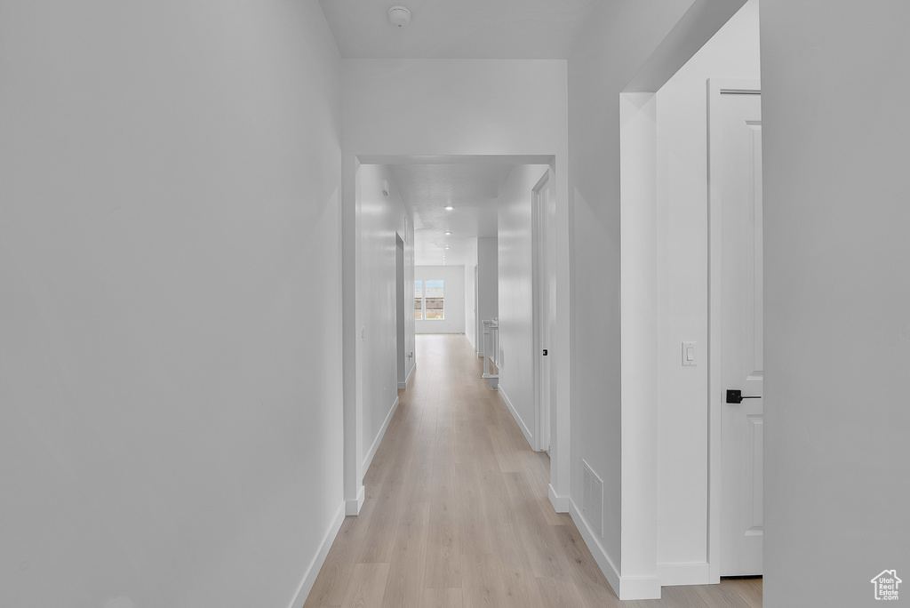 Corridor featuring light wood finished floors and baseboards