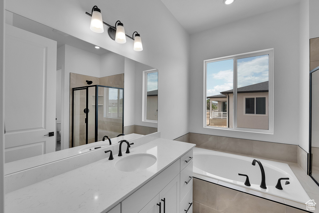 Full bath featuring vanity, a garden tub, a stall shower, toilet, and recessed lighting