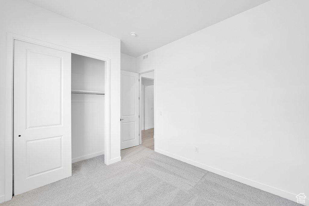 Unfurnished bedroom featuring carpet flooring, baseboards, and a closet