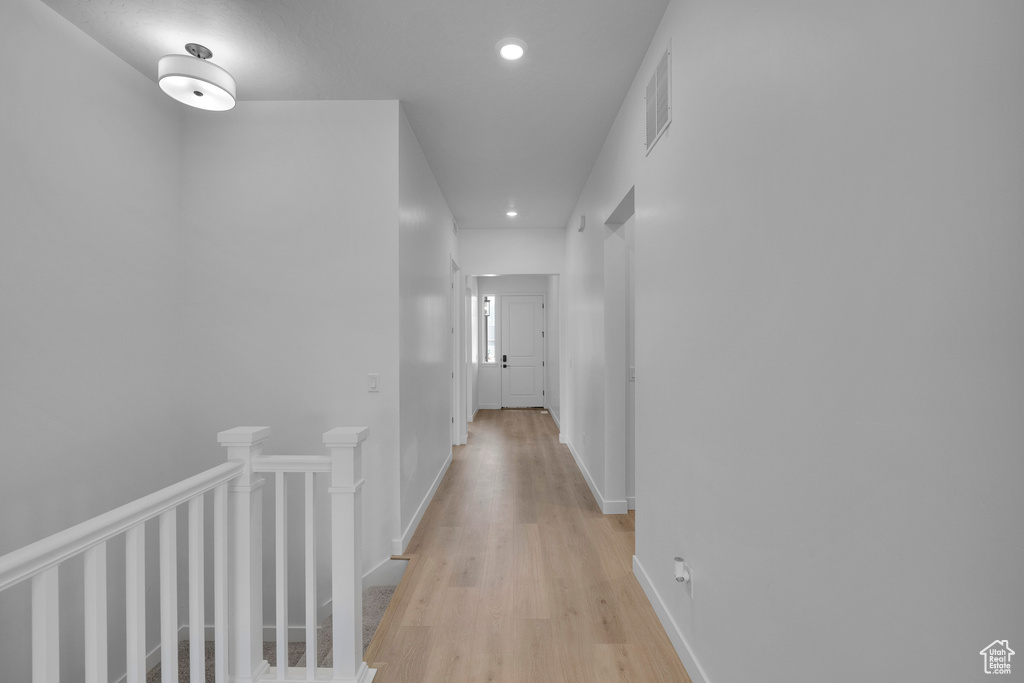 Hall with recessed lighting, light wood finished floors, an upstairs landing, and baseboards