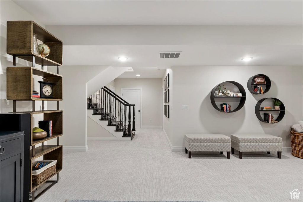 Sitting room featuring stairway, light carpet, baseboards, and recessed lighting