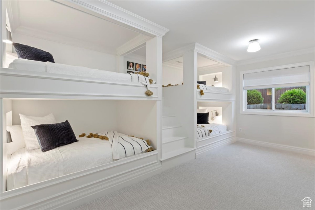 Carpeted bedroom with crown molding and baseboards