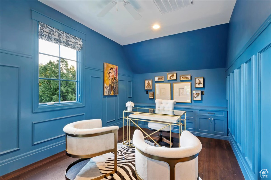 Home office featuring a decorative wall, dark wood finished floors, ceiling fan, and vaulted ceiling