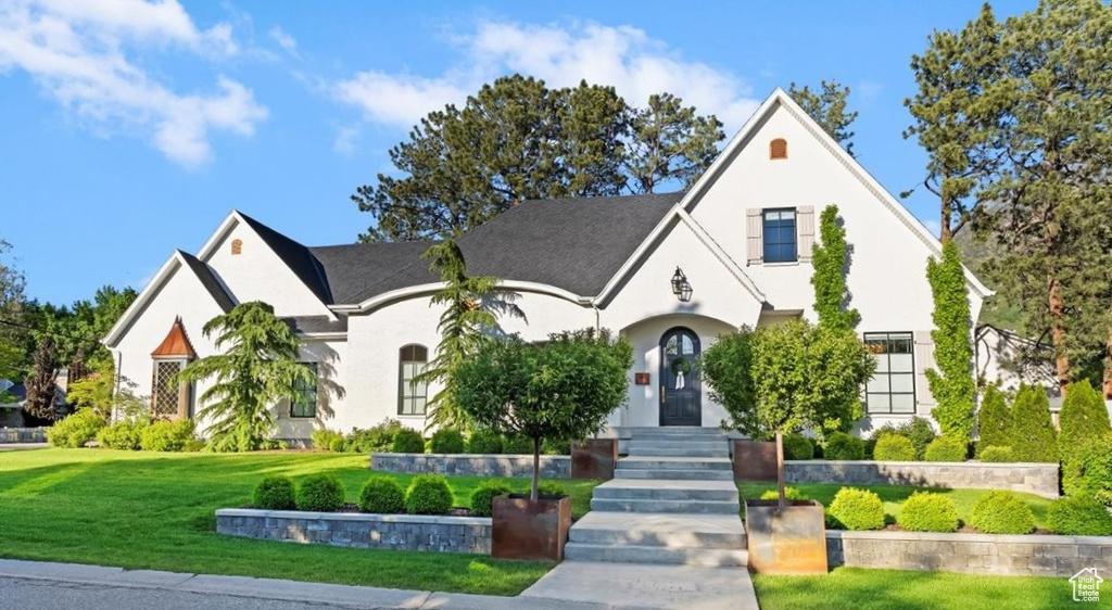 View of front facade featuring a front yard and stucco siding
