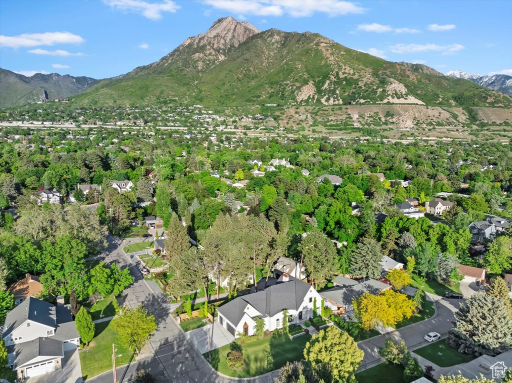 Aerial view of property and surrounding area with a mountainous background and nearby suburban area