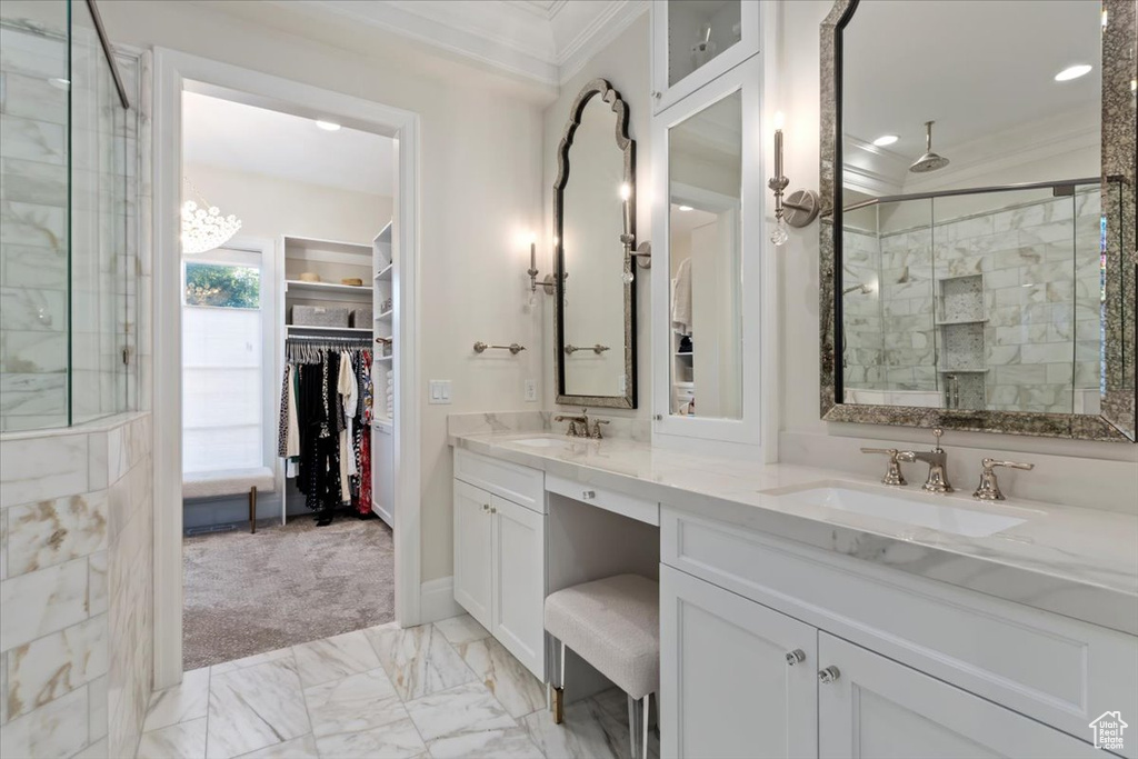 Bathroom with crown molding, double vanity, a stall shower, a walk in closet, and marble look tile flooring