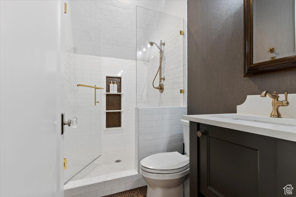 Full bath featuring toilet, vanity, and tiled shower