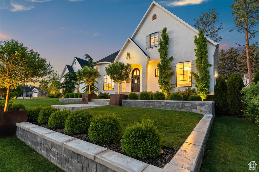 View of front of home with a yard and stucco siding