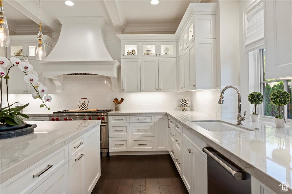 Kitchen with a sink, dishwasher, custom range hood, crown molding, and white cabinetry