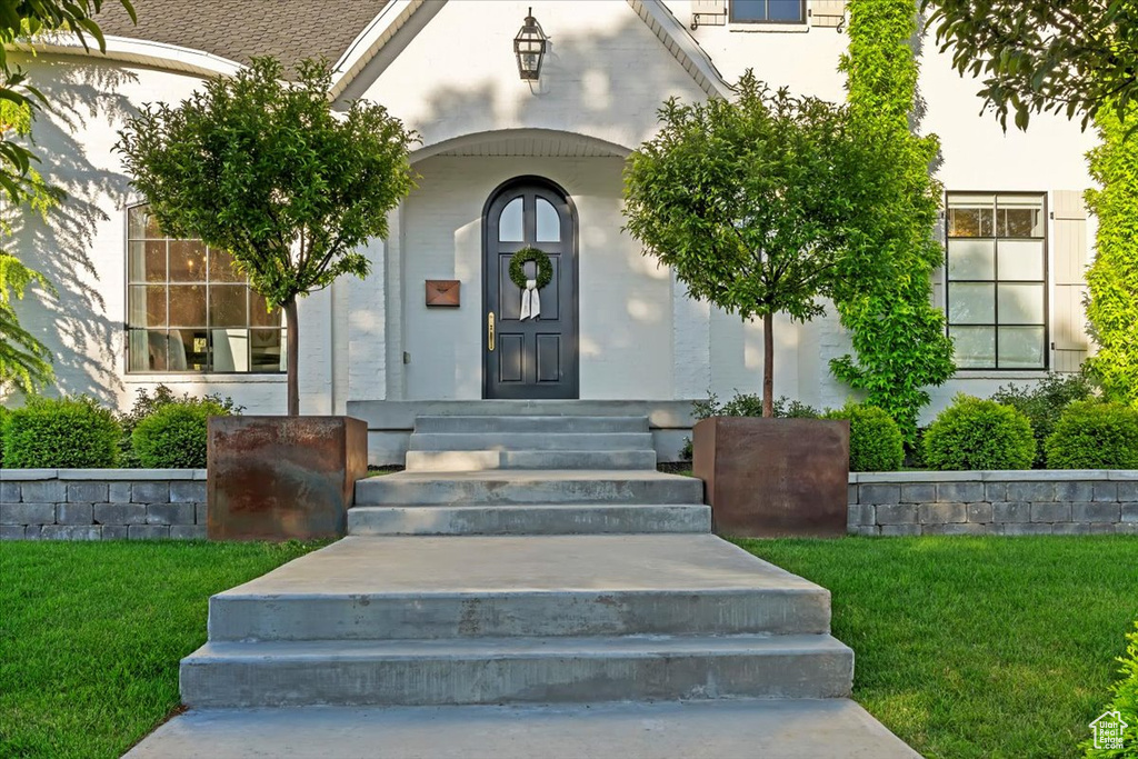 Entrance to property featuring a lawn and stucco siding