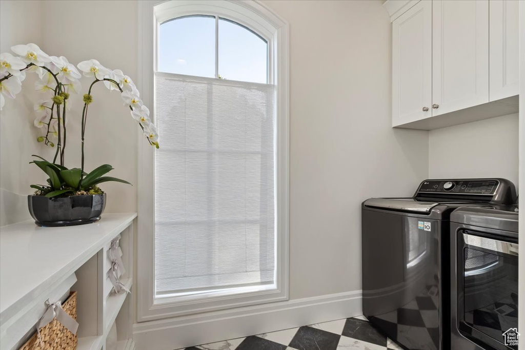 Laundry area featuring cabinet space, separate washer and dryer, and baseboards