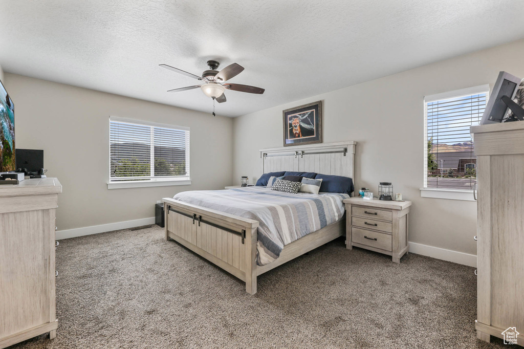 Carpeted bedroom with baseboards and a ceiling fan