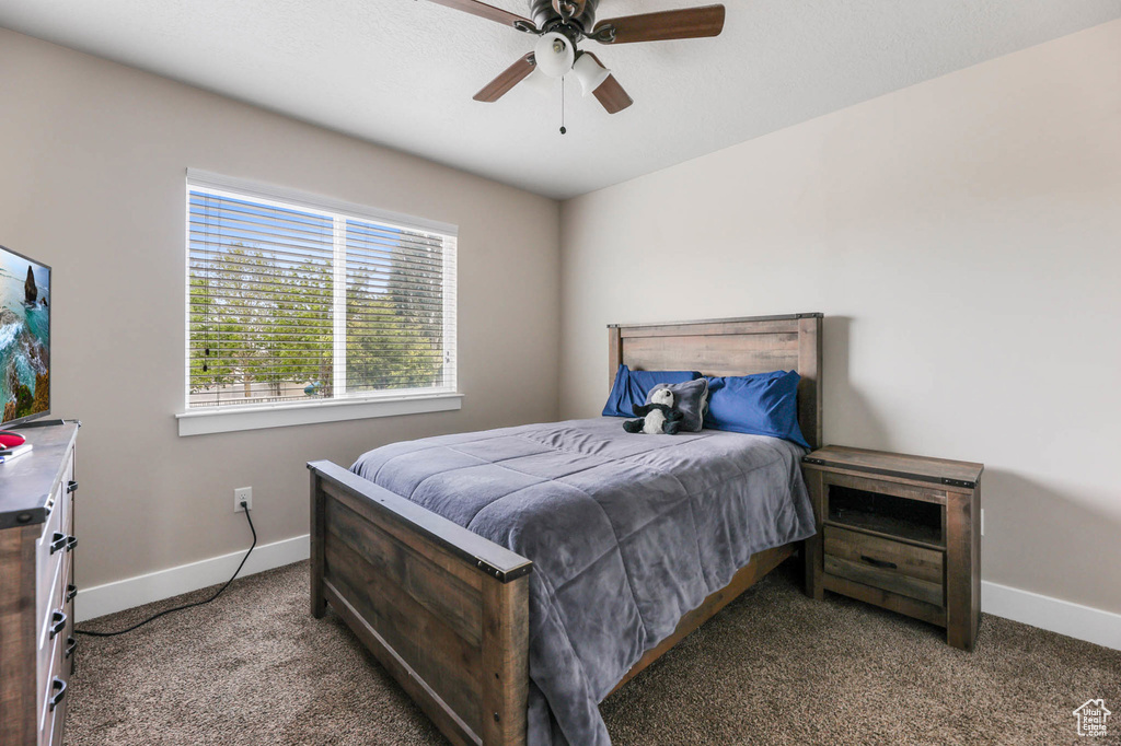 Carpeted bedroom featuring baseboards and ceiling fan