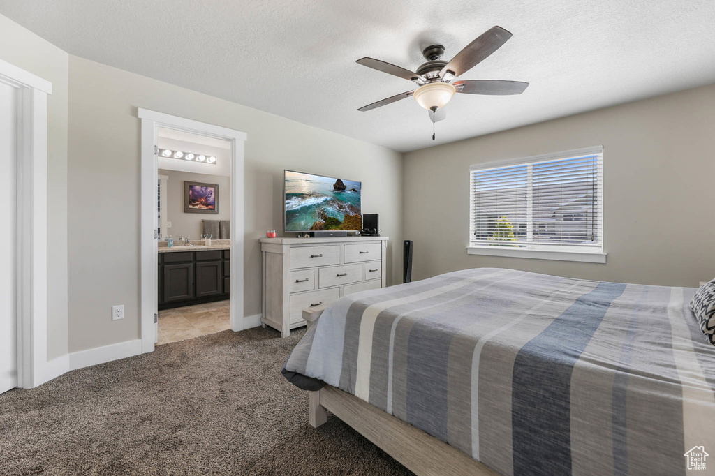 Bedroom with carpet floors, baseboards, connected bathroom, ceiling fan, and a textured ceiling