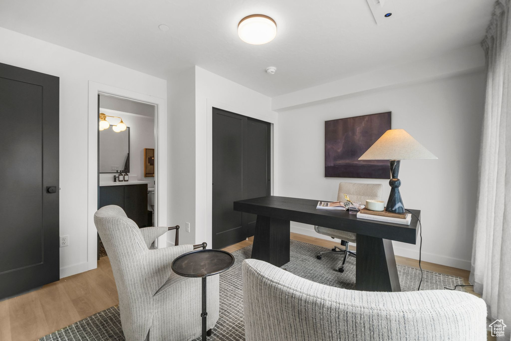 Office space with light wood-style flooring and baseboards