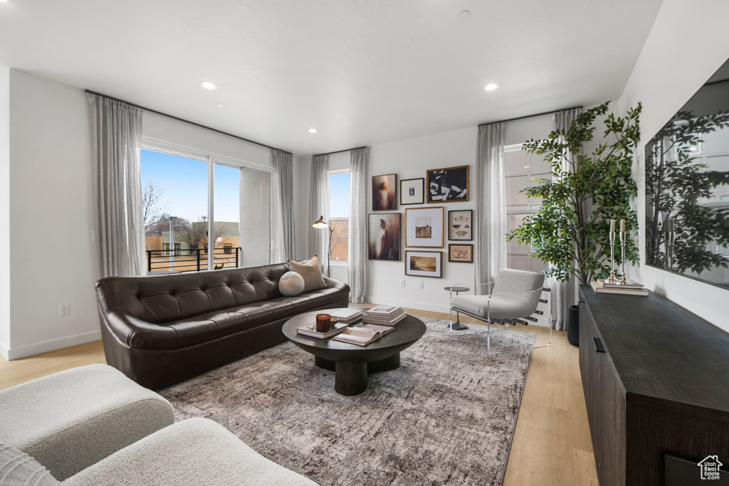 Living area with light wood finished floors, recessed lighting, and baseboards