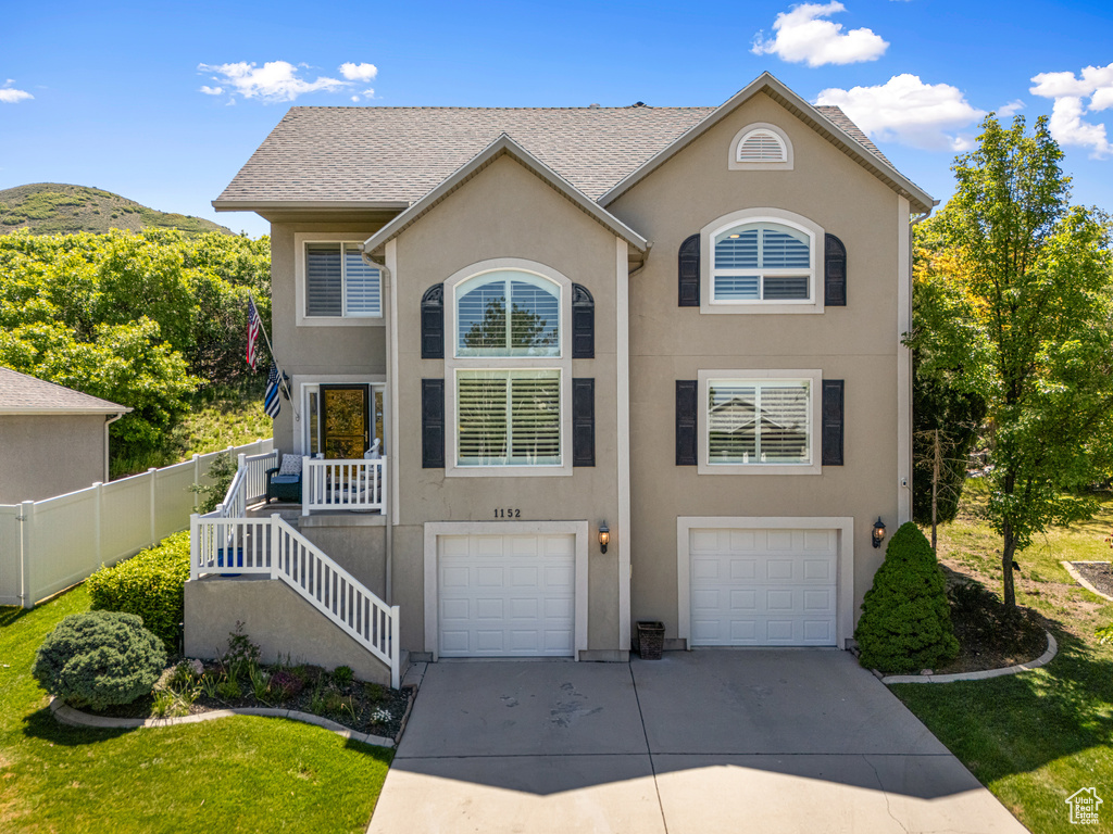 View of front of home featuring concrete driveway, an attached garage, and stucco siding