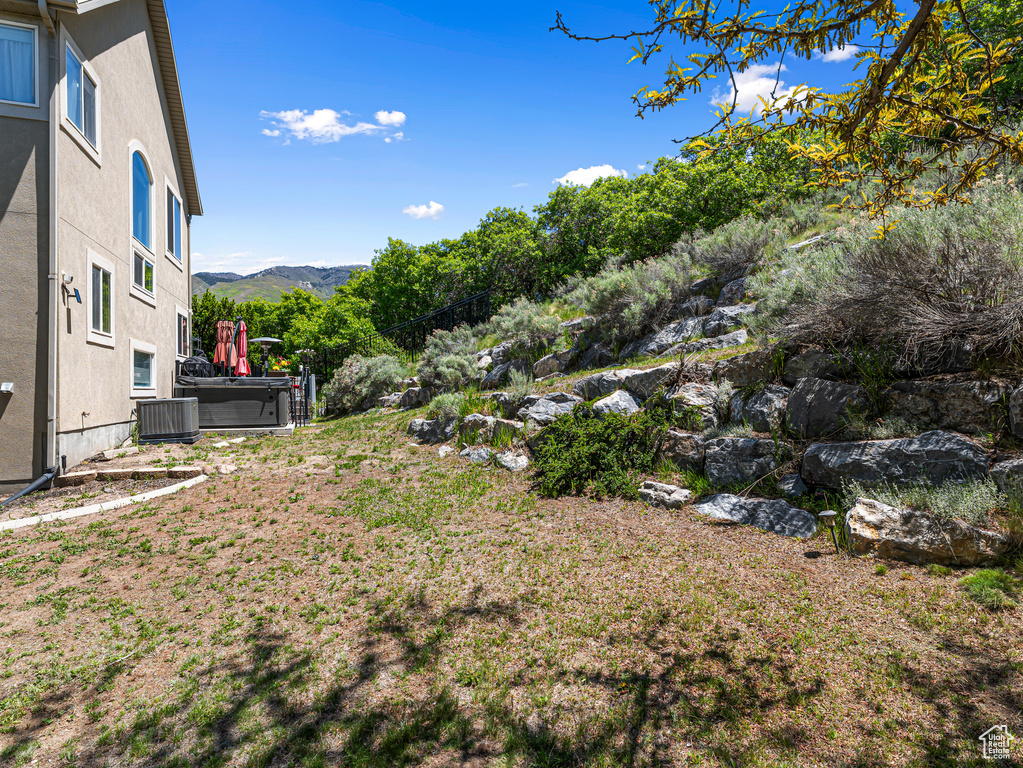 View of yard with a mountain view and central air condition unit