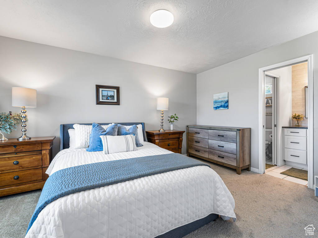 Bedroom with light carpet and ensuite bath