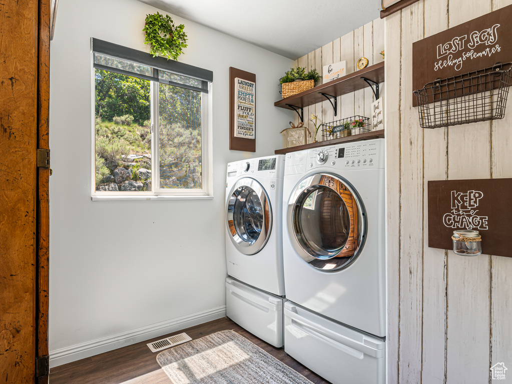Laundry area featuring washing machine and clothes dryer, wood finished floors, and baseboards