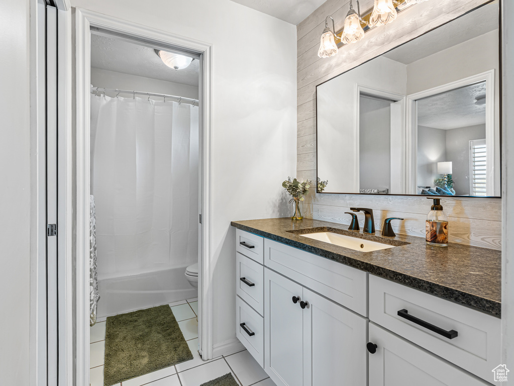 Full bath featuring vanity, tile patterned flooring, toilet, and shower / bath combination with curtain